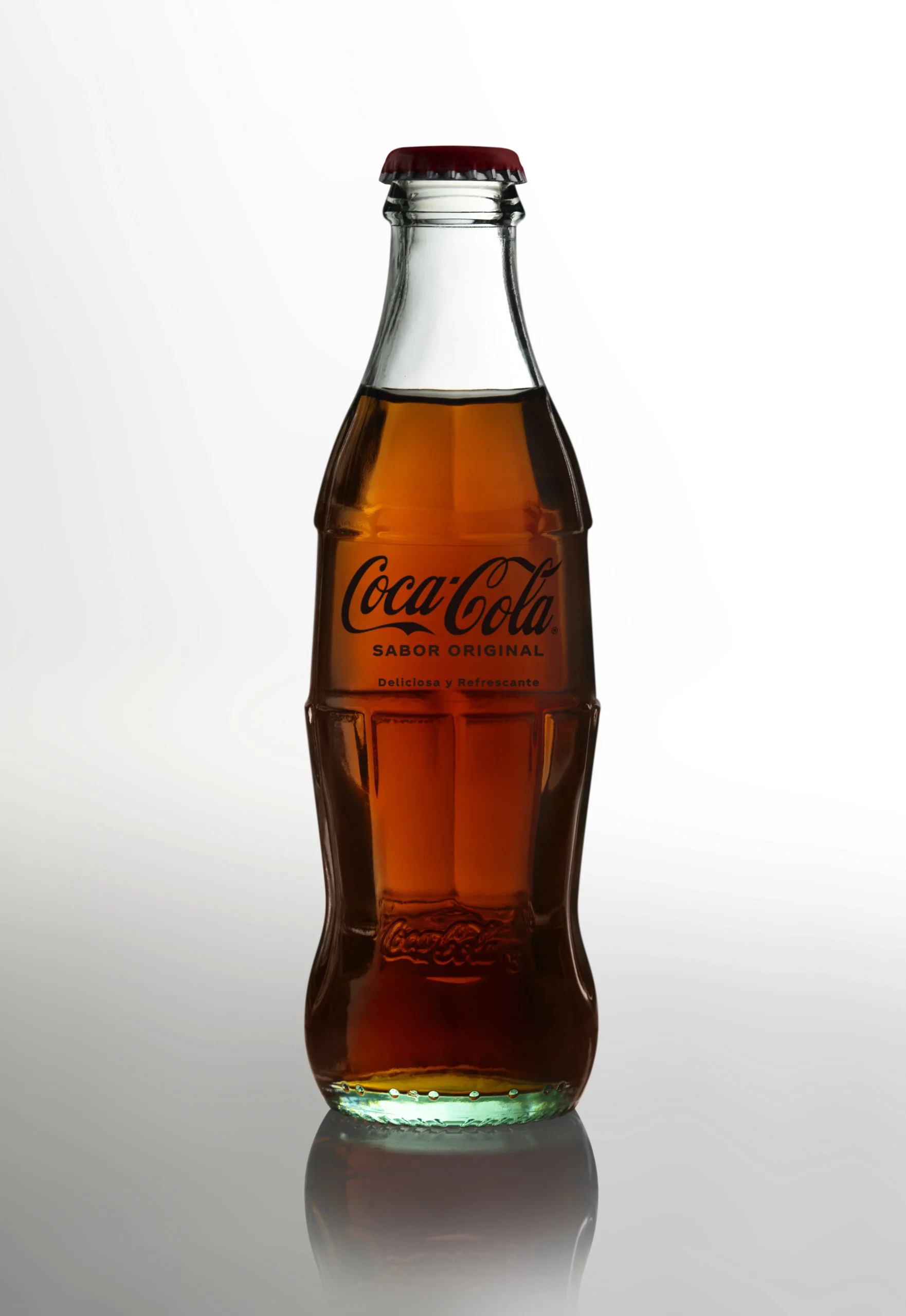 Botella de Coca-Cola sirviéndose en un vaso